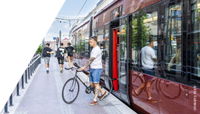 Cyclist exiting  a tram.